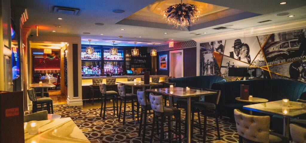 The Blue Lounge bar with high-top tables and velvet booths