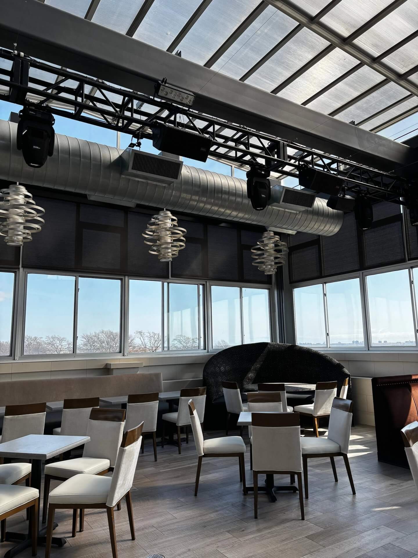 The Rooftop Lounge under its glass roof, with lounge seating and a piano
