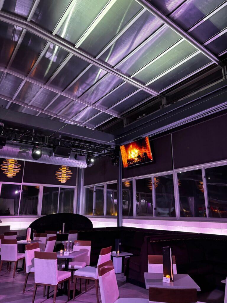 Rooftop Lounge tables and booths beside windows over the bay