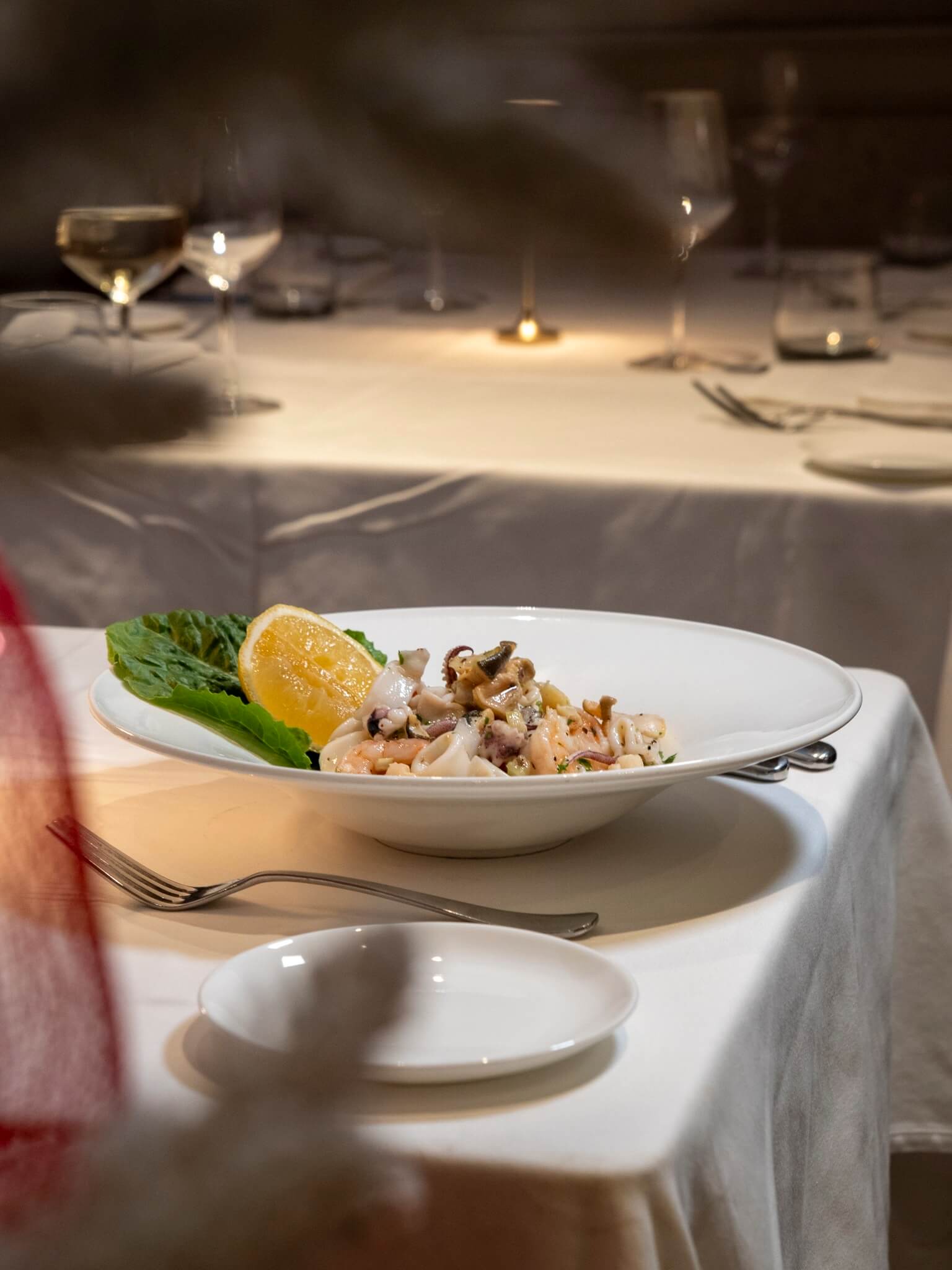 Plated seafood on a white tablecloth in the dining room
