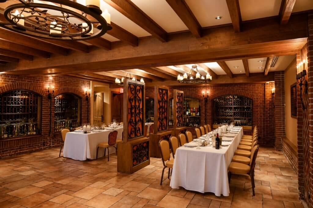 The Wine Cellar with brick arches, wine racks and long tables set for dinner
