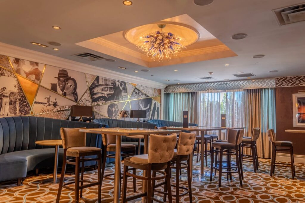 Blue Lounge booths and high-top tables beneath a glass chandelier