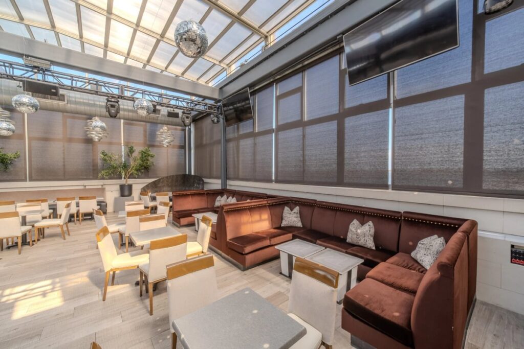 Rooftop Lounge booth and tables beneath the glass roof